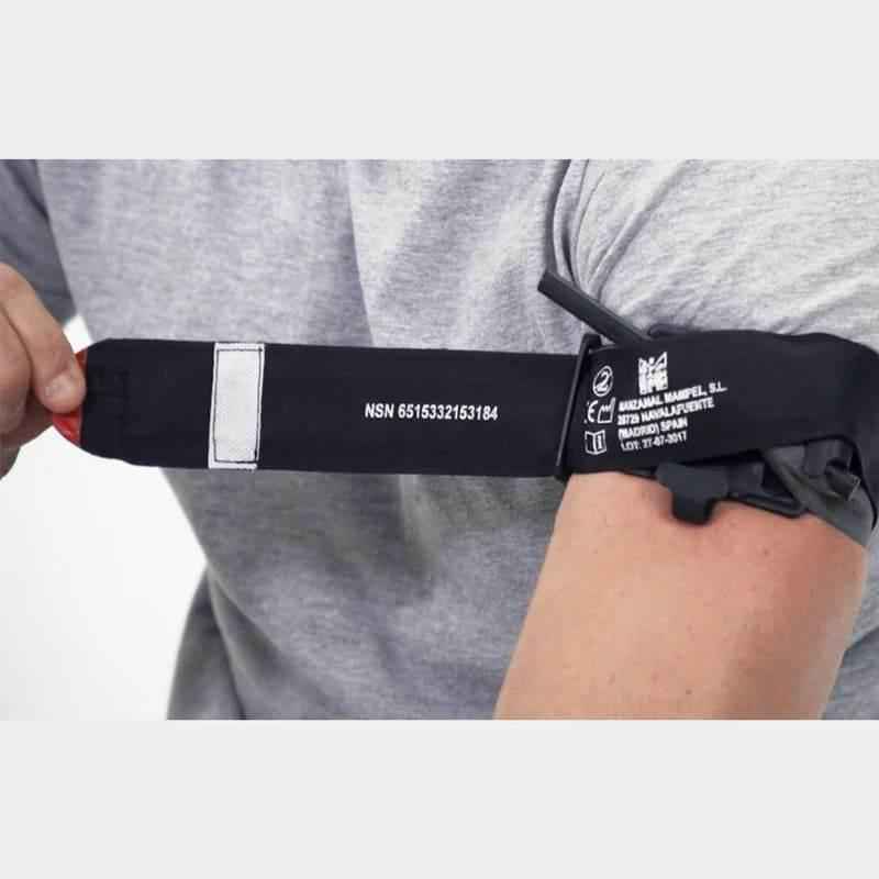 Torniquete de emergencia con banda negra y etiqueta de datos en el brazo