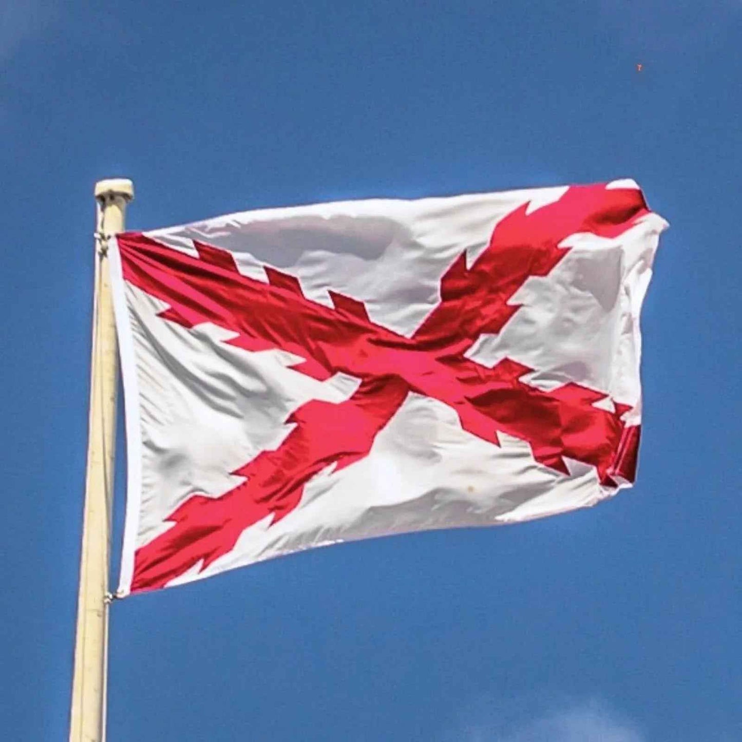 Bandera con cruz de Borgoña roja y fondo blanco, ondeando en una asta