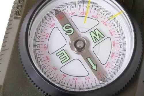 Brújula lensática negra con dial circular detallado con letras y marcas