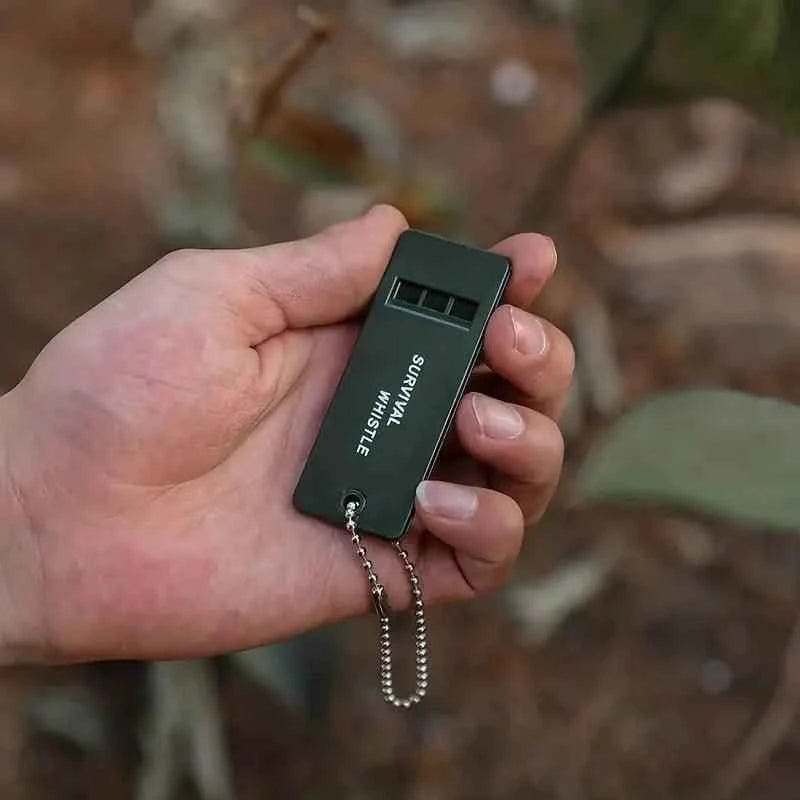 Silbato de supervivencia verde compacto con cadena metálica plateada